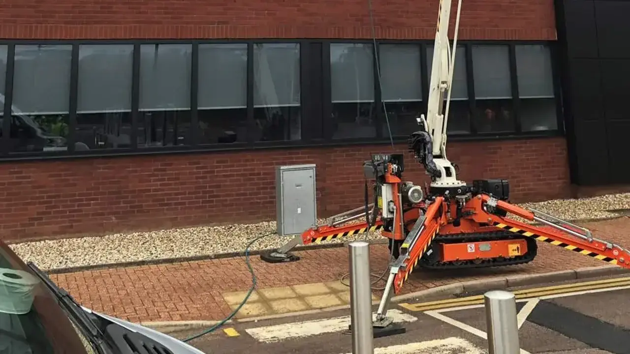 Spider cherry picker extended to full height between commercial buildings
